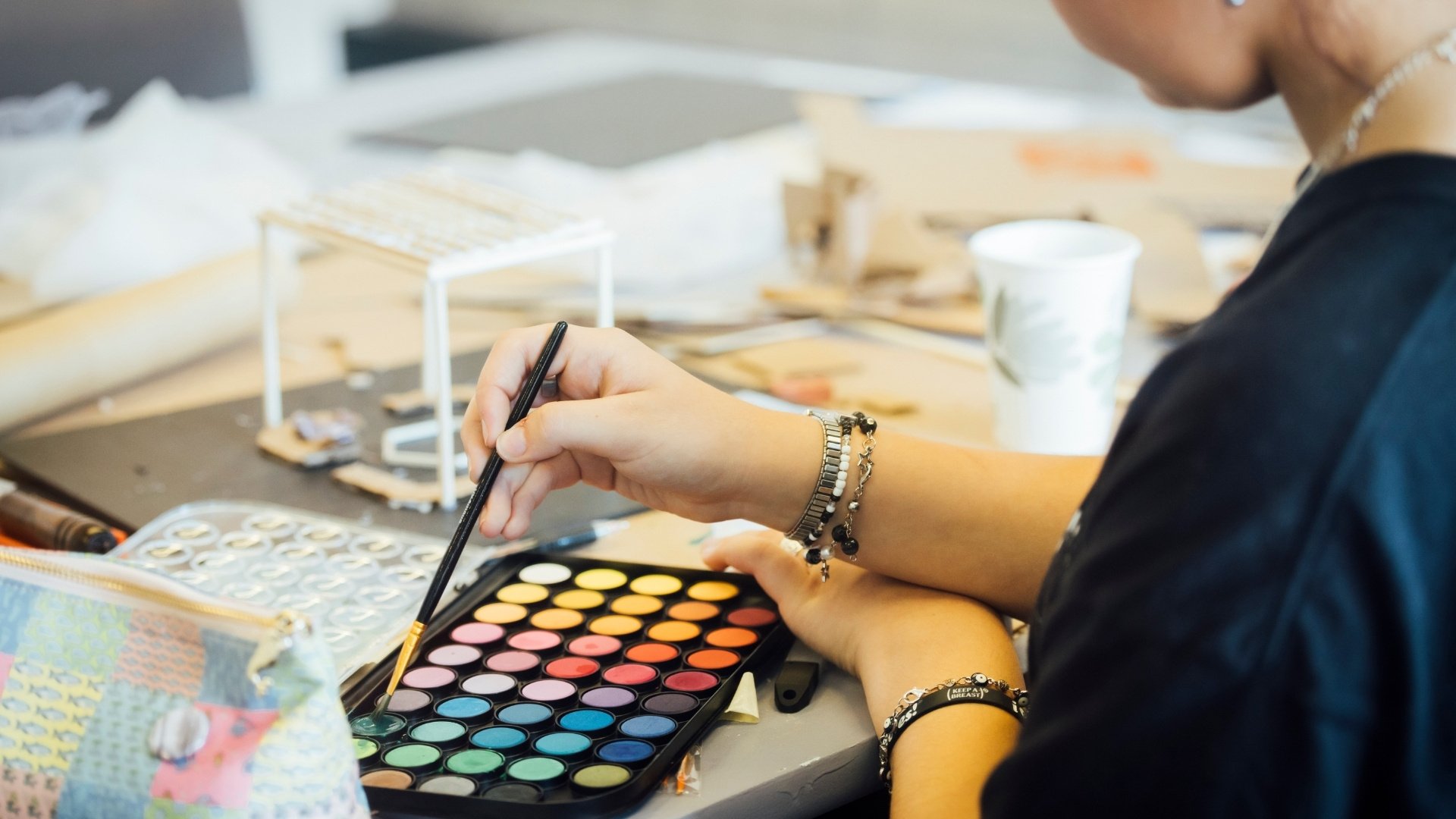 Student painting with watercolor paint.