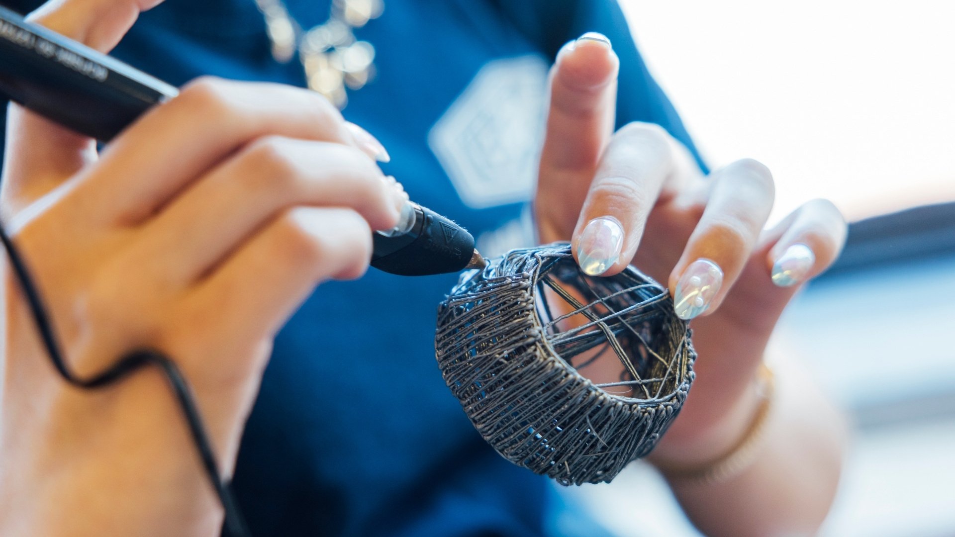 Student creating with a 3D printing pen.